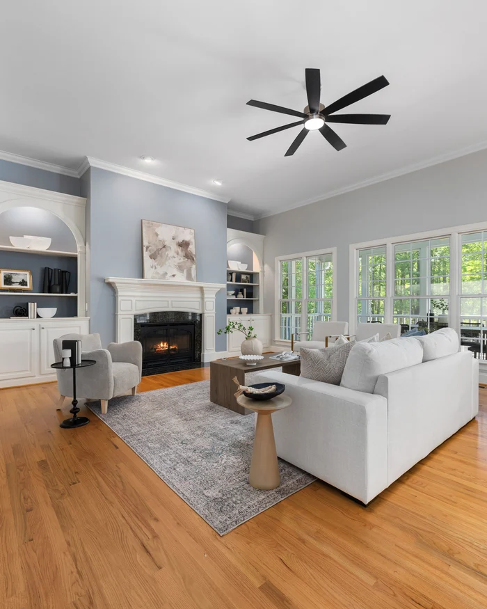 Living room with freshly painted blue and gray walls, white built ins and crisp baseboards