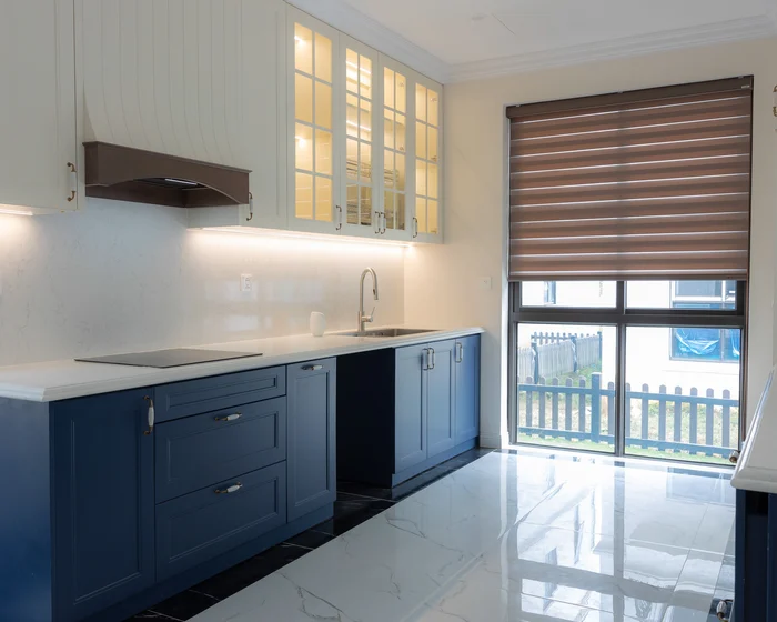 Kitchen with lower cabinets painted navy blue and upper cabinets painted white